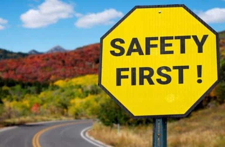 Yellow Safety First sign by winding road