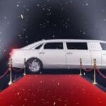 White stretch limousine on red carpet with spotlights