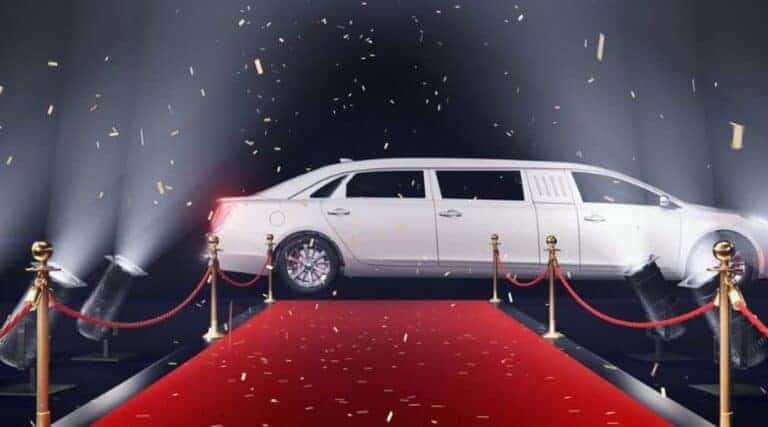 White stretch limousine on red carpet with spotlights