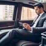 Businessman using tablet in luxury car backseat