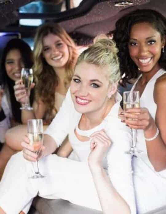 Friends celebrating with champagne in limousine