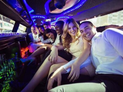Friends partying inside a neon-lit limousine.