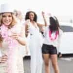 Woman celebrating with champagne in front of limousine
