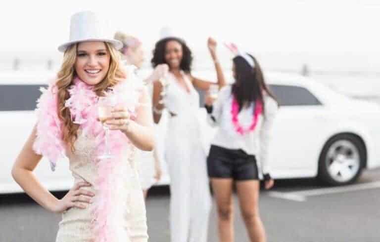 Woman celebrating with champagne in front of limousine