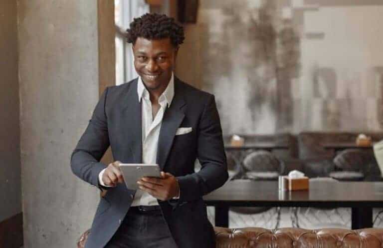 Smiling businessman using tablet in modern cafe