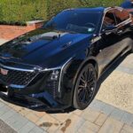 Black Cadillac sedan parked on driveway