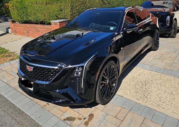 Black Cadillac sedan parked on driveway