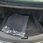 Car trunk with floor mats wrapped in plastic