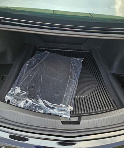 Car trunk with floor mats wrapped in plastic