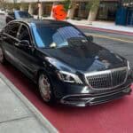 Black luxury sedan parked on city street curb