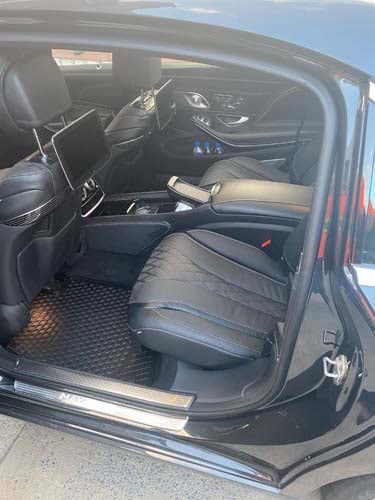 Luxury car rear interior with leather seats and screens