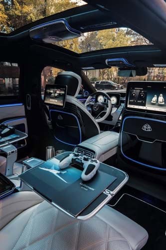 Luxury car interior with gaming setup and panoramic roof