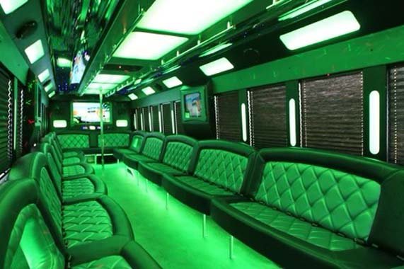 Green-lit luxury party bus interior with bench seating