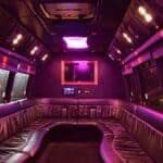 Purple-lit luxury party bus interior with leather seating