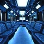 Blue-lit luxury party bus interior with leather seating