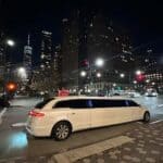 White stretch limousine on city street at night