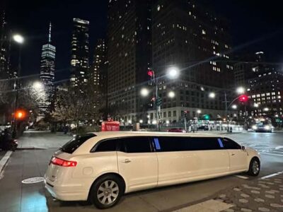 White stretch limousine on city street at night