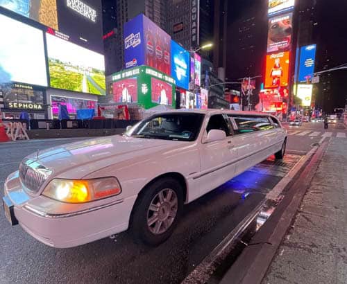 White stretch limousine in Times Square at night