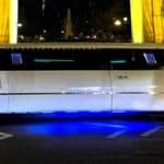 White stretch limousine with blue underglow at night