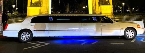 White stretch limousine with blue underglow at night