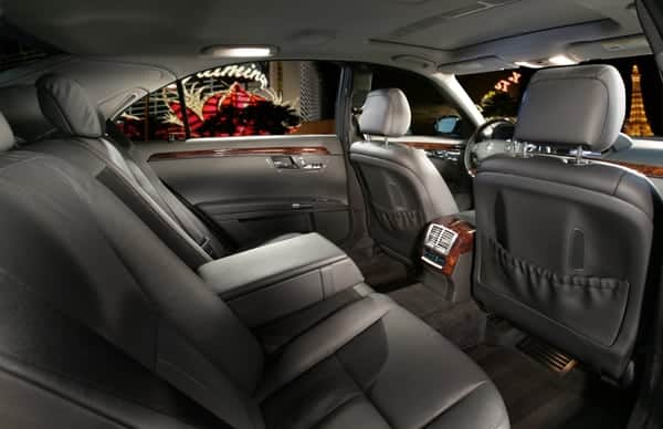 Luxury car interior with leather seats and city lights