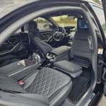Luxury car interior with black quilted leather seats