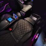 Luxury car interior with quilted seats and purple lighting