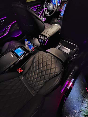 Luxury car interior with quilted seats and purple lighting