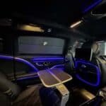 Luxury car interior with blue ambient lighting and table