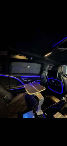 Luxury car interior with blue ambient lighting and table