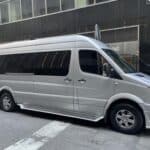 Silver passenger van parked on city street
