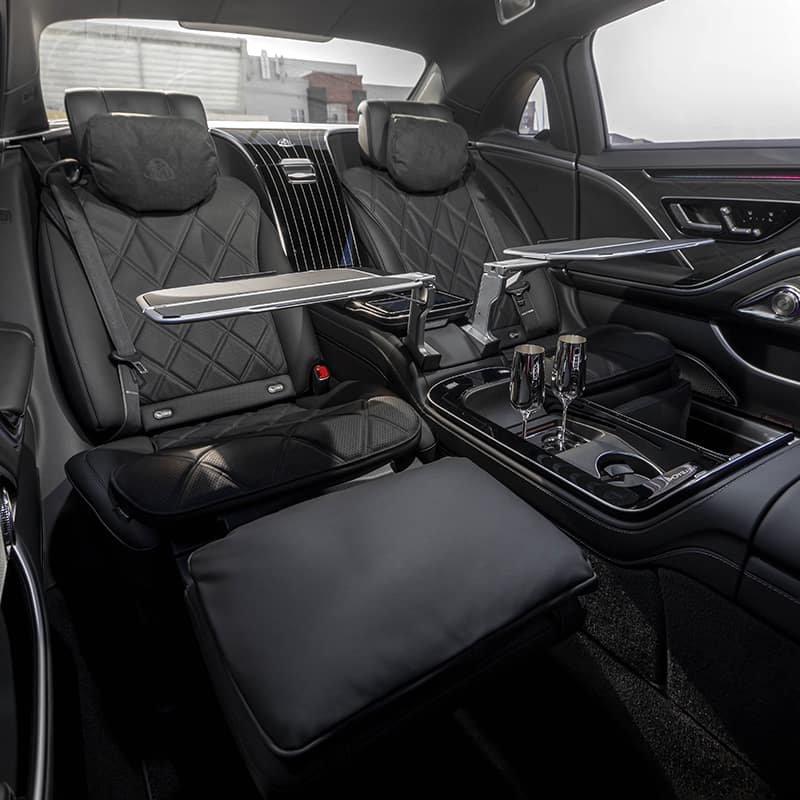 Luxury car rear seats with tray tables and glasses