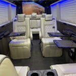 Luxury van interior with cream leather seats and tables