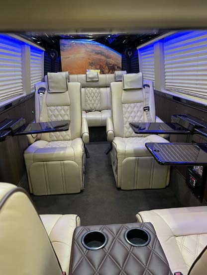 Luxury van interior with cream leather seats and tables