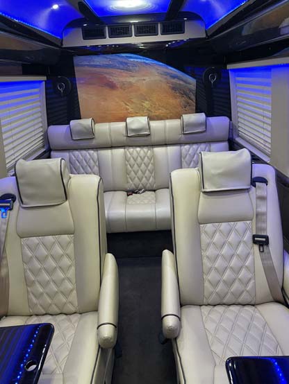 Luxury van interior with cream leather seats and blue lighting