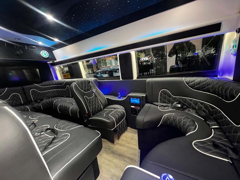 Luxury party bus interior with quilted leather and starry ceiling.