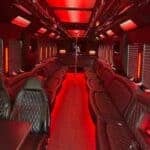 Red-lit luxury party bus interior with leather seating