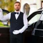 Chauffeur opening luxury car door in formal attire