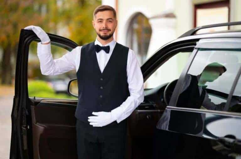 Chauffeur opening luxury car door in formal attire