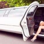 Woman sitting in open white limousine door