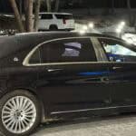 Black luxury sedan parked at night in snow