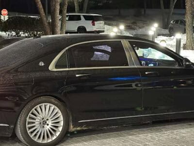 Black luxury sedan parked at night in snow