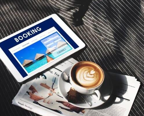 Tablet showing booking page beside coffee and magazine