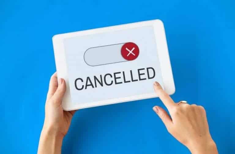 Hands holding tablet displaying cancelled message with red X