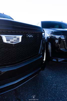 Close-up of two black Cadillac front grilles