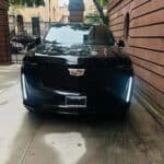 Black Cadillac SUV parked in narrow driveway