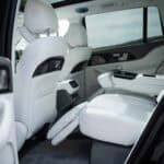 Luxury car rear interior with reclining white leather seats