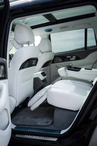 Luxury car rear interior with reclining white leather seats