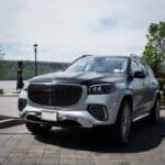 White luxury SUV parked by waterfront driveway