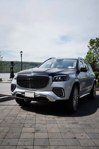 White luxury SUV parked by waterfront driveway